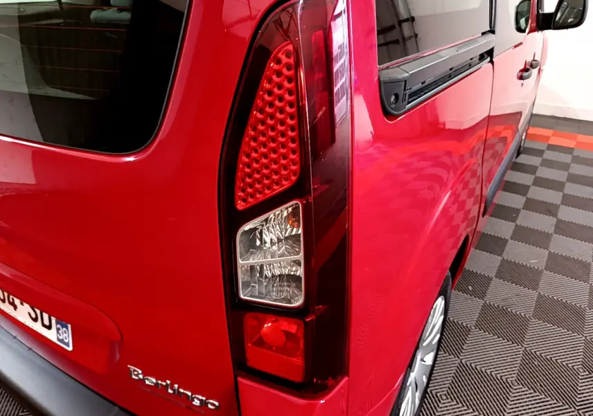 Vue 3/4 arrière droite du Citroën Berlingo rouge mettant en valeur son feu arrière vertical et sa vitre latérale.