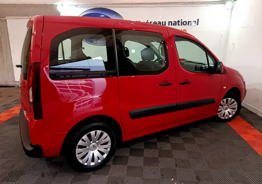 Vue 3/4 arrière droite d'un Citroën Berlingo rouge de 2016 avec vitres teintées et jantes en acier.