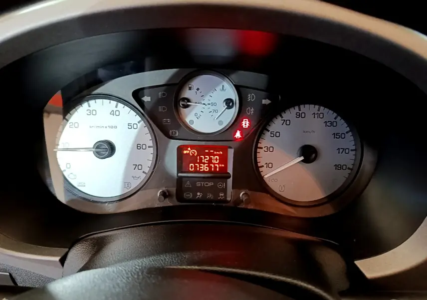 Vue rapprochée du tableau de bord du Citroën Berlingo rouge 2016, affichant compte-tours, vitesse et témoins lumineux allumés.