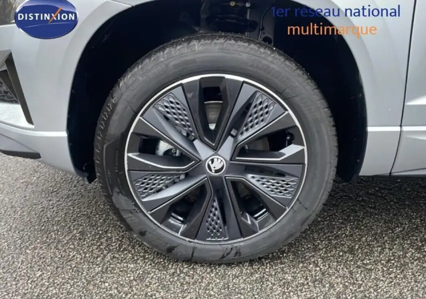 Gros plan sur la roue avant droite argentée d’un Skoda Karoq 1.5 TSI 2025 avec jante noire et détails géométriques.