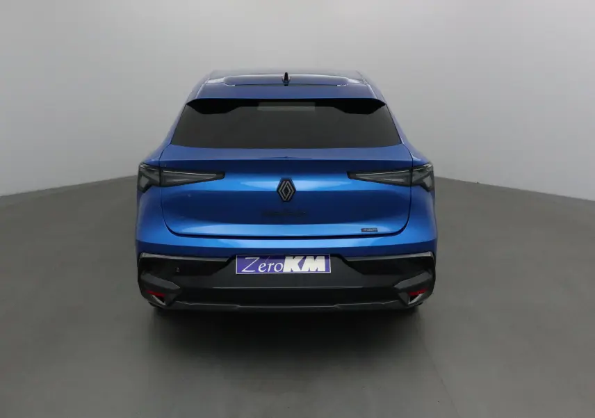 Vue arrière d'une Renault Rafale 2025 bleu sommet avec feux arrière fins et logo central noir sur fond gris.