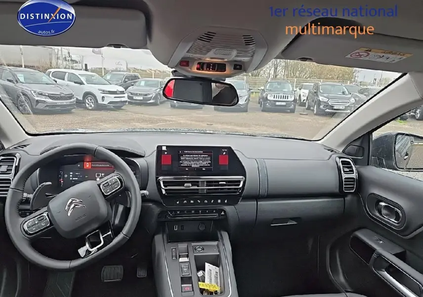 Vue intérieure avant du Citroën C5 Aircross 2025, tableau de bord noir avec écran tactile et volant multifonction.