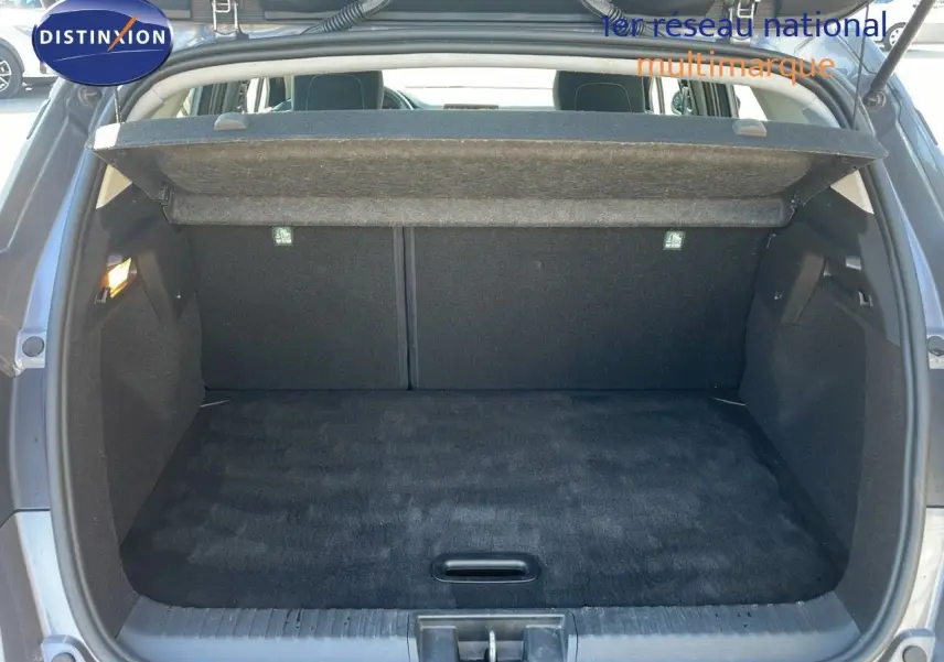 Coffre ouvert vu de l'arrière du Renault Captur gris Cassiopée métal, montrant un espace de chargement propre et spacieux.