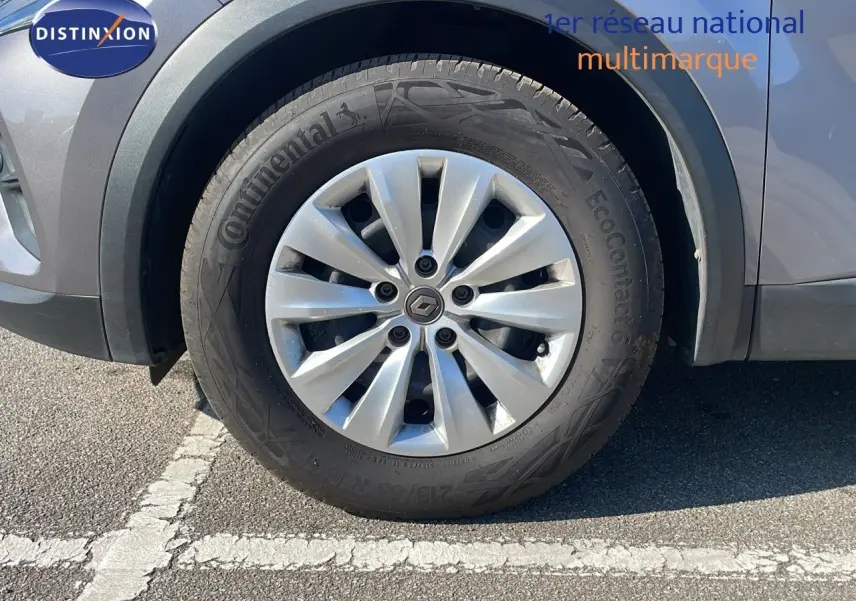 Gros plan sur la roue avant gauche d'un Renault Captur gris Cassiopée Métal avec jante alliage et pneu Continental.