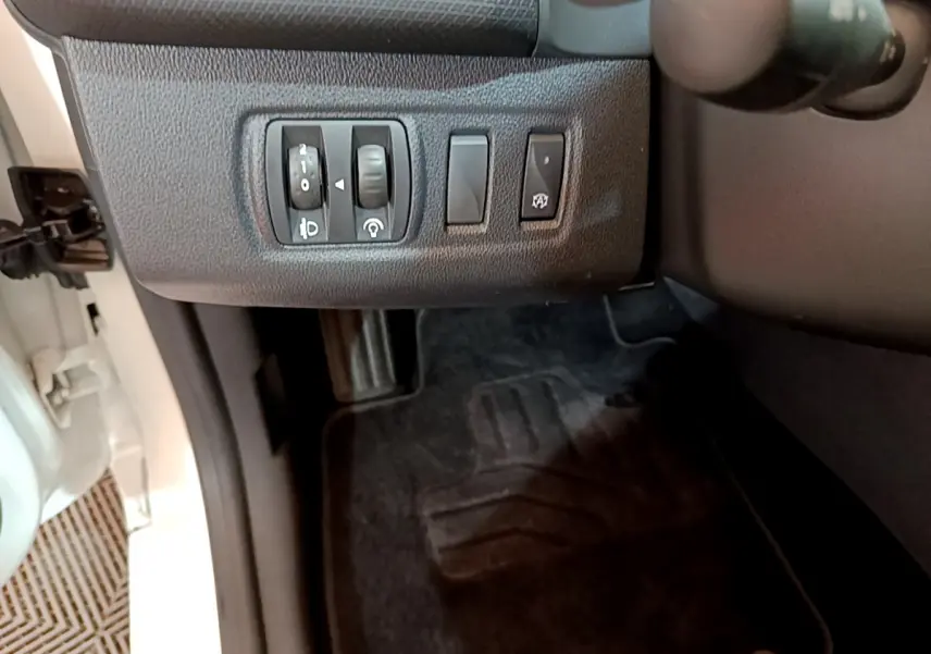 Vue rapprochée des commandes d'éclairage et du tableau de bord côté gauche dans une Renault Clio Business blanche de 2019.