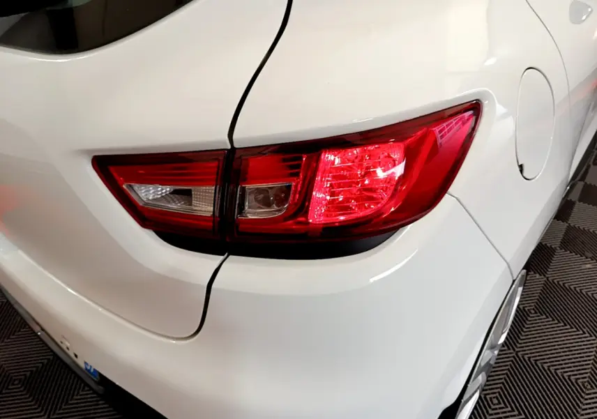 Gros plan sur le feu arrière droit d'une Renault Clio Business TCe 90 blanche, avec la trappe à carburant visible.