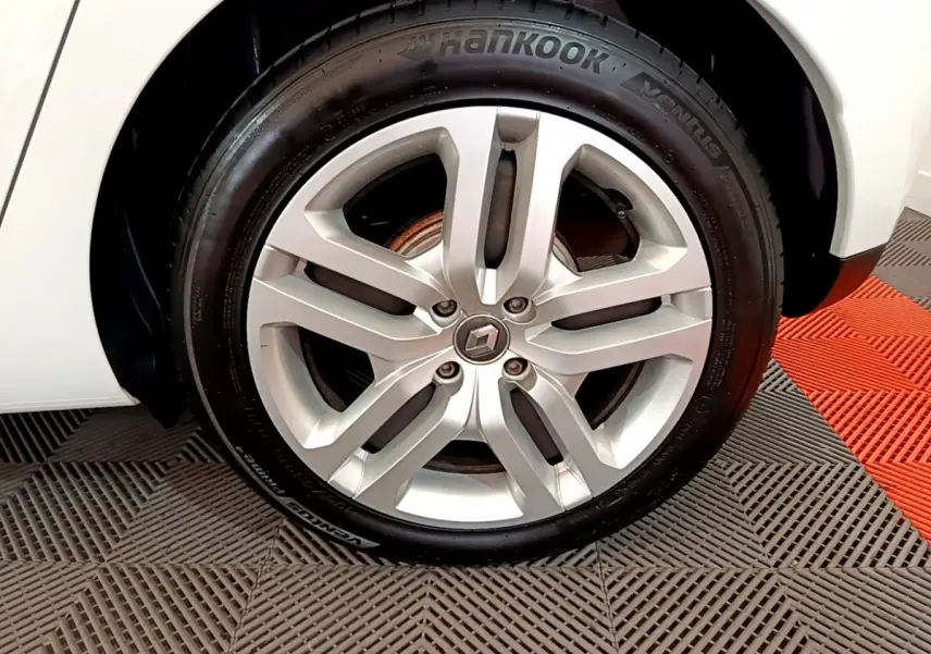 Gros plan sur la roue avant droite d'une Renault Clio Business TCe 90 blanche avec jante alliage et pneu Hankook.