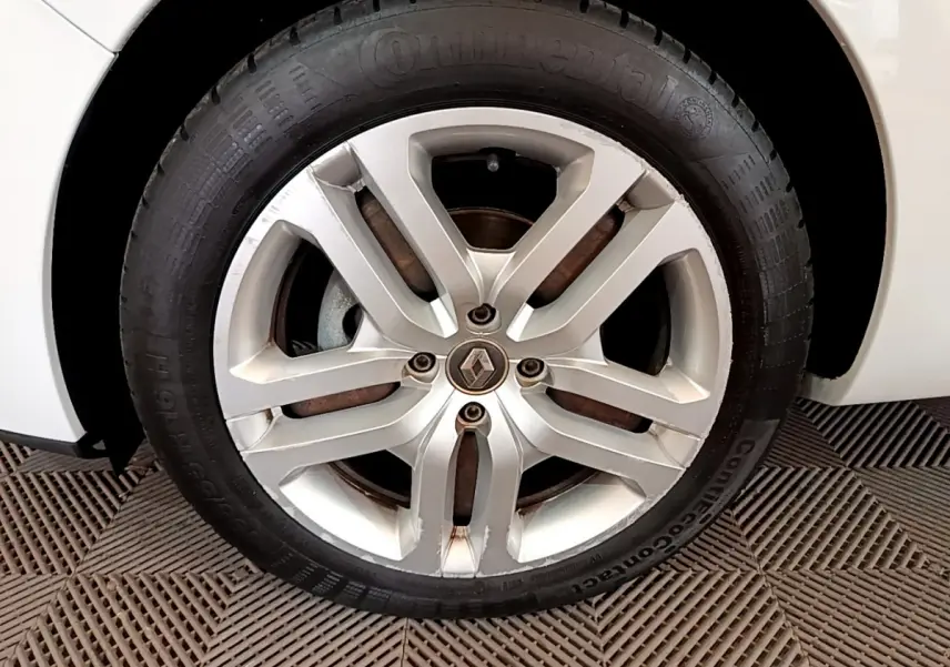 Gros plan sur la roue avant droite blanche d'une Renault Clio Business TCe 90 avec jante alliage et logo Renault central.