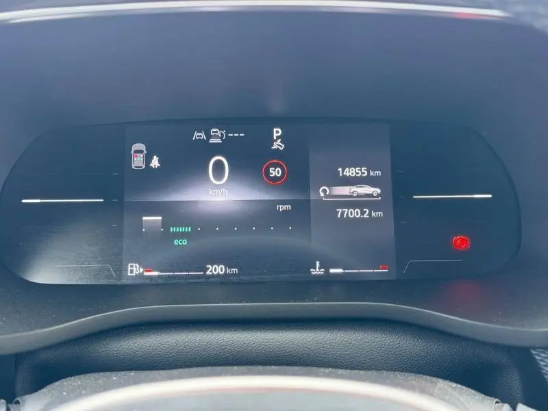Vue rapprochée du tableau de bord numérique du Renault Arkana blanc 2025, affichant la vitesse à 0 km/h et l'autonomie restante.
