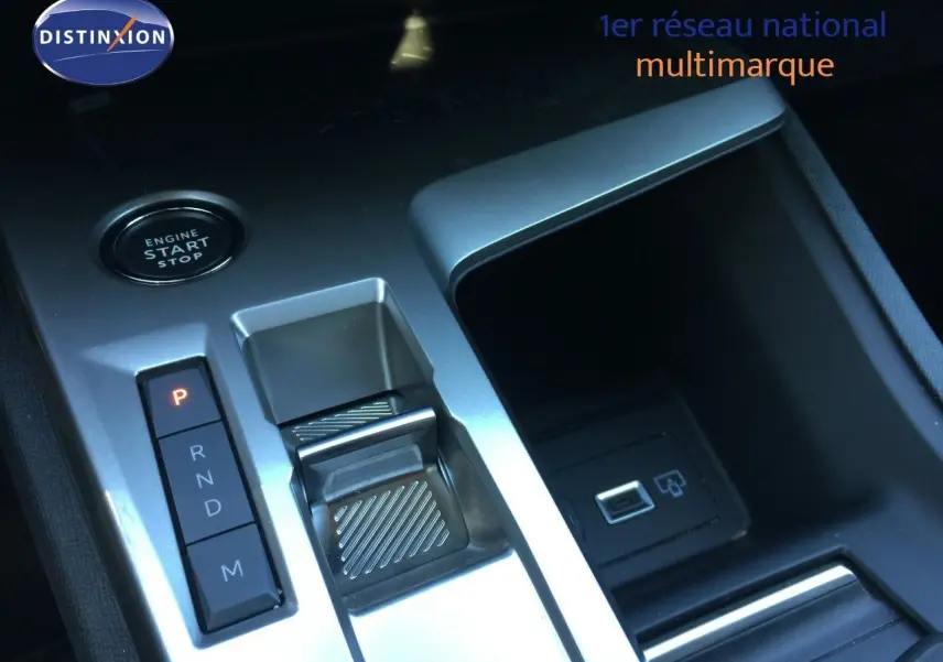 Gros plan sur la console centrale de la Peugeot 308 gris Artense, montrant la commande de boîte auto et le bouton start/stop.