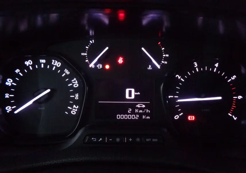 Tableau de bord éclairé du Peugeot Expert Long 2023, affichant 2 km au compteur et voyants d'alerte allumés.