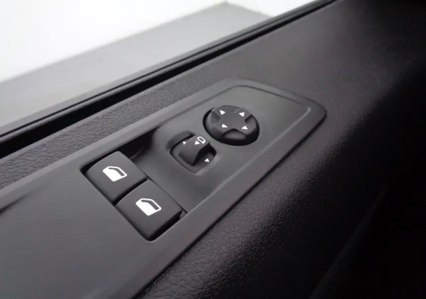 Gros plan sur les commandes de réglage des vitres et des rétroviseurs côté conducteur du Peugeot Expert Long noir Perla Metal 2023.