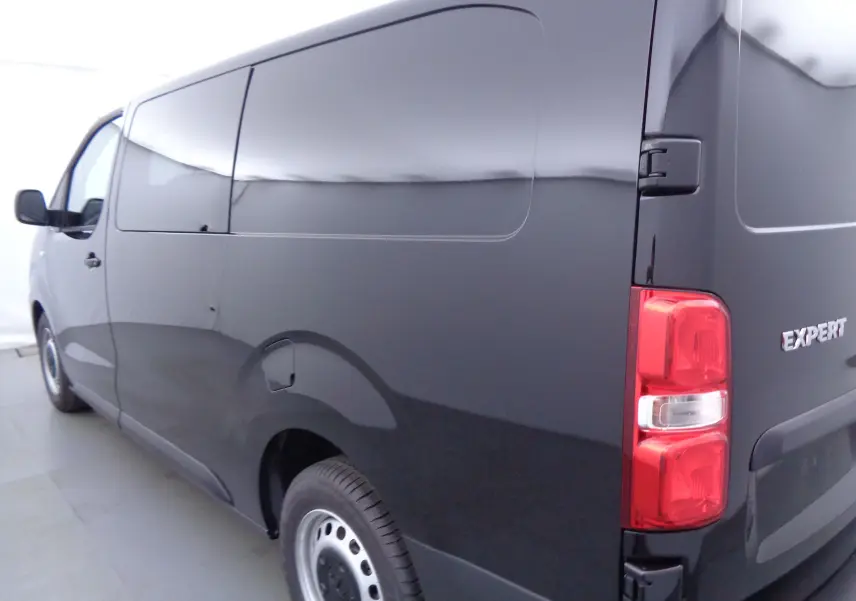 Vue 3/4 arrière droite d'un Peugeot Expert Long noir Perla Metal avec portes latérales et feux arrière rouges.
