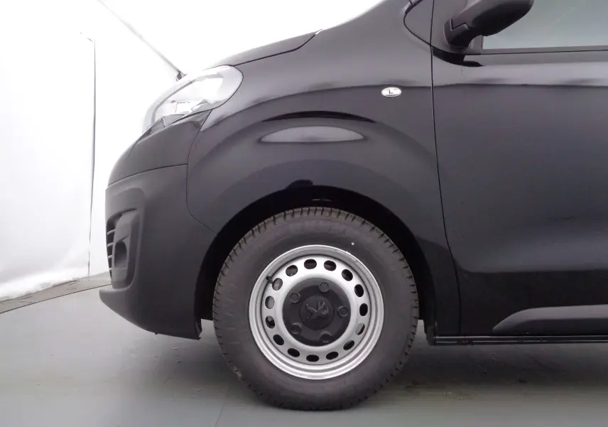 Vue latérale côté gauche du Peugeot Expert Cabine Approfondie noir Perla Metal, mettant en valeur la roue avant acier et le passage de roue.