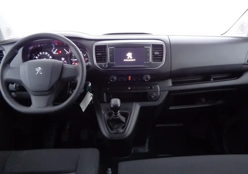 Vue intérieure avant du Peugeot Expert Long 2023, tableau de bord noir avec volant, écran tactile et levier de vitesse manuel.