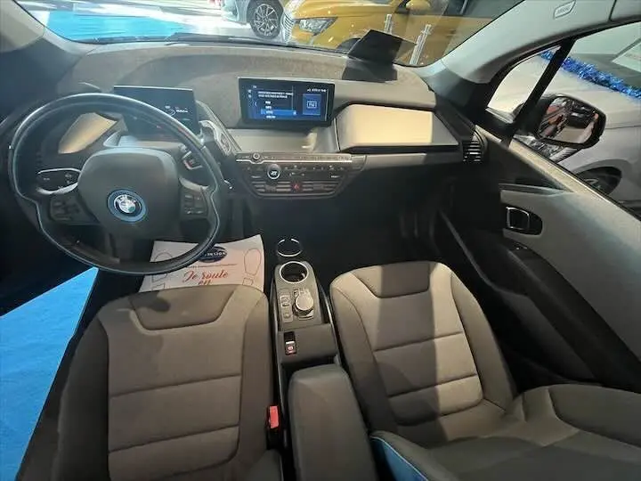 Intérieur de la BMW i3 noir, vue de dessus montrant le tableau de bord moderne et les sièges gris bleuté.