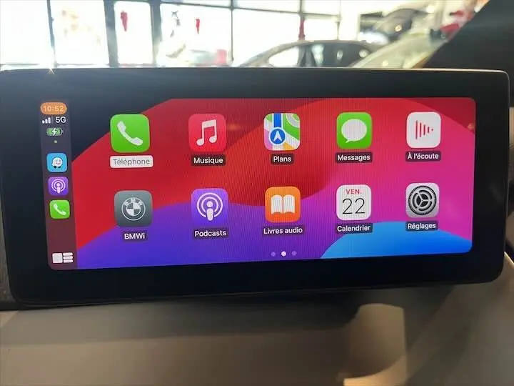 Écran tactile multimédia intérieur de BMW i3 noir, affichant les applications Apple CarPlay colorées.