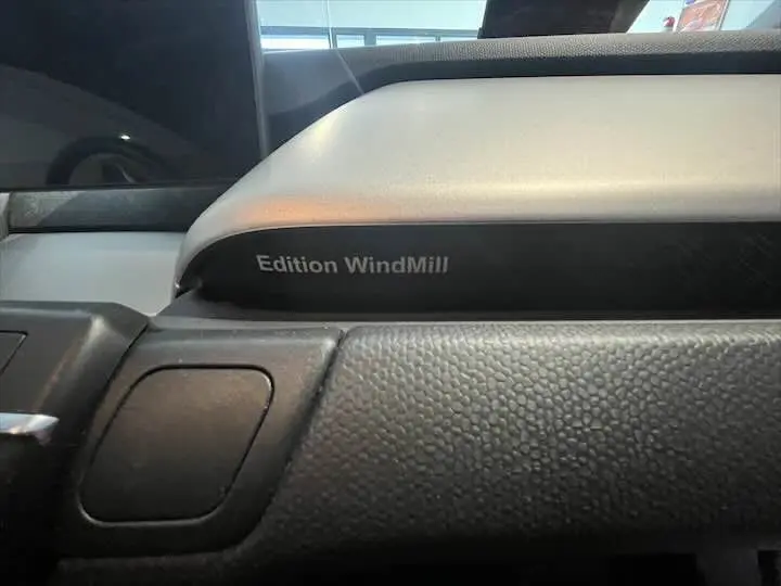 Détail intérieur du tableau de bord gris bleu avec l'inscription Edition WindMill visible sur une BMW i3 noire.