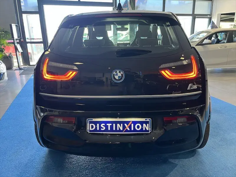 Vue arrière d'une BMW i3 noire avec feux LED allumés et plaque d'immatriculation Distinxion en showroom.