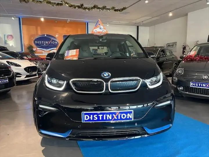 BMW i3 S noire vue de face en intérieur, avec calandre caractéristique et plaque Distinxion visible