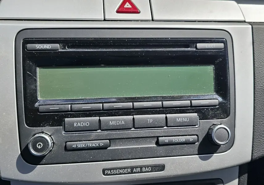 Gros plan sur la console centrale de la Volkswagen Passat 2009, montrant l'autoradio et la clé de contact insérée.