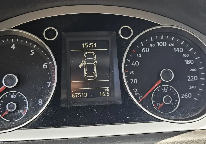 Tableau de bord de Volkswagen Passat 2009 montrant compte-tours, vitesse, niveau carburant et écran central d'information.