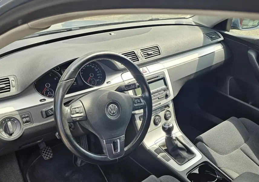 Intérieur de la Volkswagen Passat 1.4 TSI 2009, vue côté conducteur, volant cuir et tableau de bord gris.