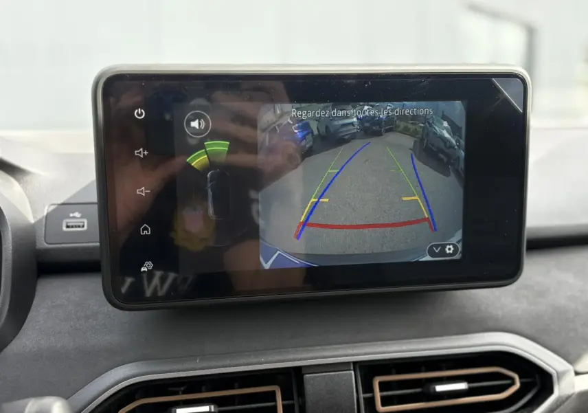 Écran tactile intérieur affichant la caméra de recul du Dacia Jogger Gris Schiste avec lignes de guidage colorées.