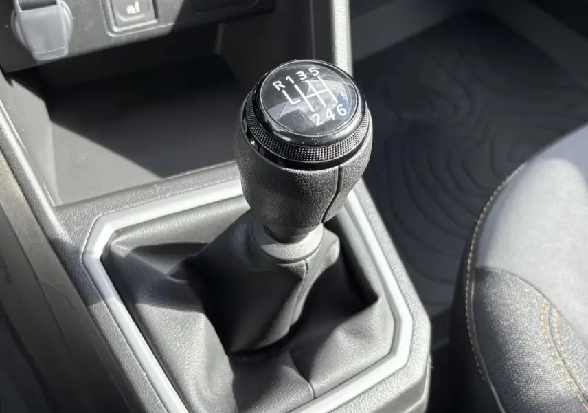 Le levier de vitesses manuel noir du Dacia Jogger gris Schiste, vu en gros plan depuis l'avant droit de l'habitacle.