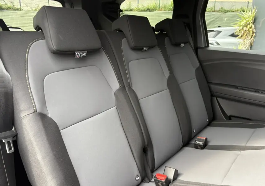 Vue latérale des sièges arrière gris du Dacia Jogger 2025, version ECO-G 100 Extreme avec appuie-têtes et ceintures visibles.