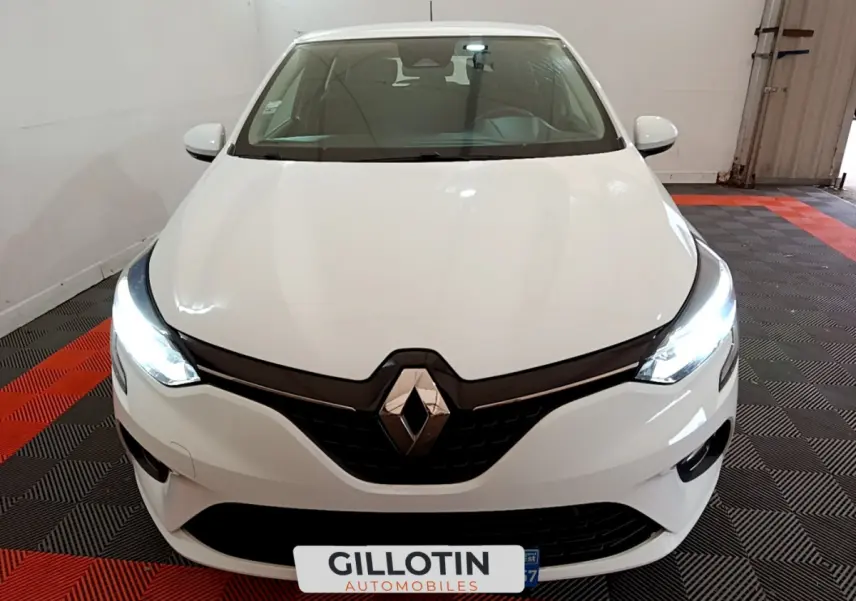Vue avant d'une Renault Clio Business Blue dCi 85 blanche avec phares LED allumés dans un garage.