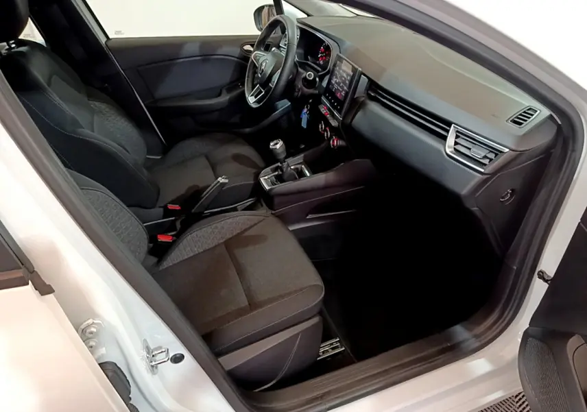 Intérieur de la Renault Clio Business Blue dCi 85 blanc, vue côté conducteur montrant sièges et tableau de bord moderne.