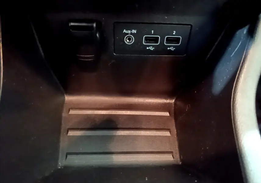 Vue rapprochée des ports USB et prise Aux-IN dans le compartiment central d'une Renault Clio blanche 2020.