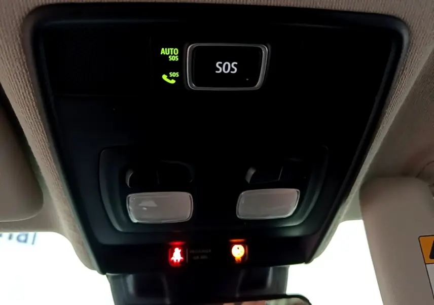 Vue en contre-plongée du plafonnier noir avec bouton SOS et voyants d'alerte dans une Renault Clio blanche 2020.