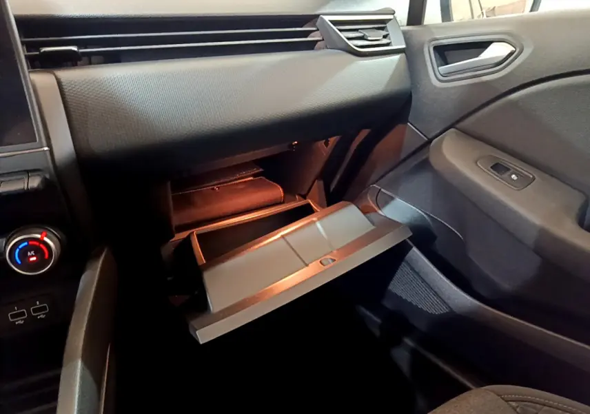 Vue intérieure côté passager de la Renault Clio Business Blue dCi 85 2020, boîte à gants ouverte et tableau de bord noir.