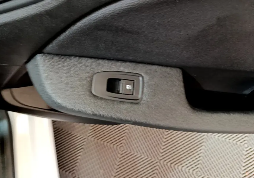 Bouton de commande de lève-vitre sur la porte intérieure côté droit d'une Renault Clio blanche Business Blue dCi 85 2020.