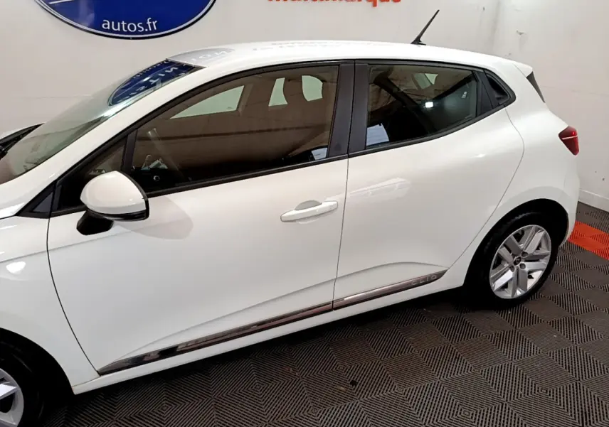 Profil côté gauche d'une Renault Clio Business Blue dCi 85 blanche, avec jantes alliage et poignées de porte assorties.