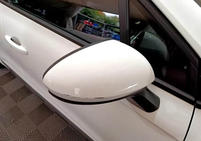 Gros plan sur le rétroviseur côté gauche blanc de la Renault Clio Business Blue dCi 85 blanche avec portière visible.