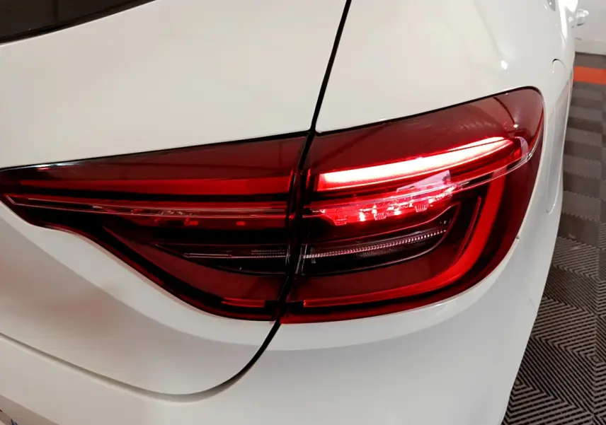 Gros plan sur le feu arrière droit rouge d'une Renault Clio Business Blue dCi 85 blanche de 2020.