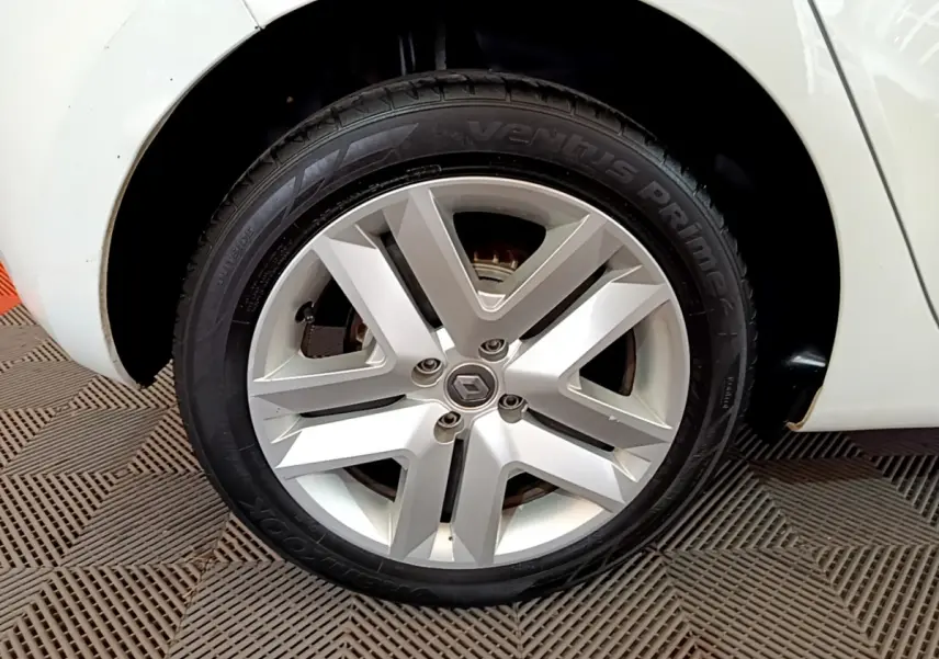 Gros plan sur la roue avant droite de la Renault Clio Business Blue dCi 85 blanche, avec jante alliage argentée.