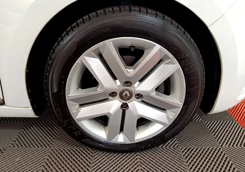 Gros plan sur la roue avant droite blanche d'une Renault Clio Business Blue dCi 85 avec jante alliage argentée.