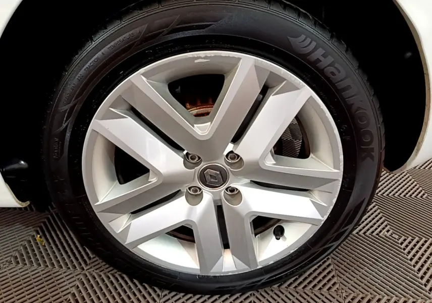 Gros plan sur la roue avant droite blanche d'une Renault Clio Business Blue dCi 85 avec jante alliage moderne.