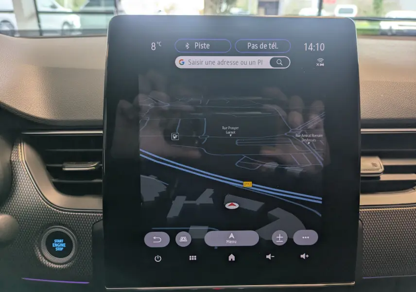 Vue rapprochée de l'écran tactile central noir affichant la navigation du Renault Arkana 2023, avec bouton Start Engine Stop à gauche.