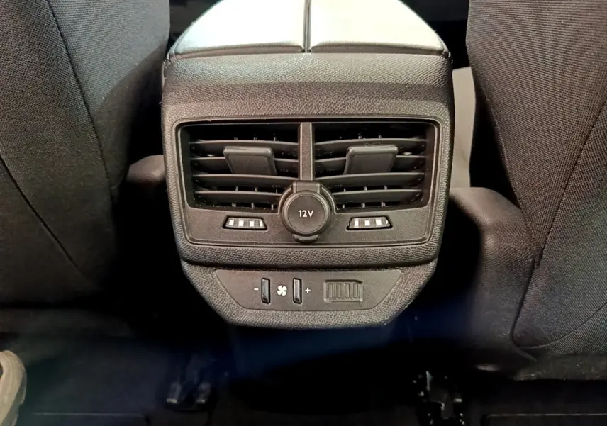 Vue rapprochée des aérateurs arrière et prise 12V noirs entre les sièges arrière du Peugeot 5008 bleu.