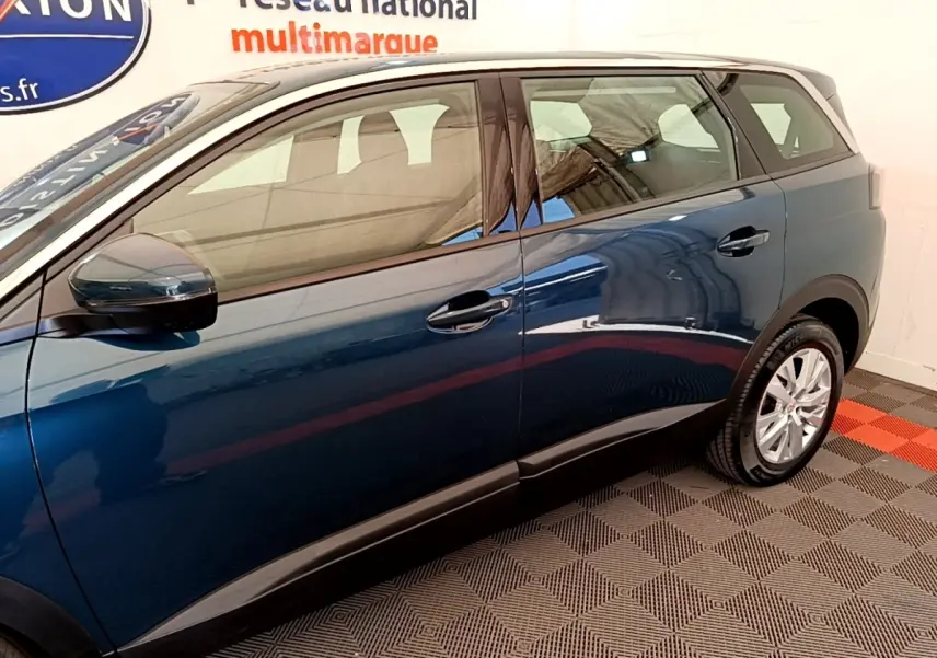 Vue latérale côté droit d'un Peugeot 5008 bleu 2021 avec jantes alliage et rétroviseurs ton caisse.
