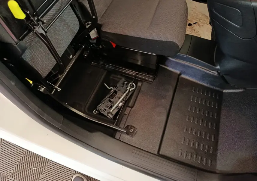 Vue intérieure côté passager du Peugeot Partner blanc 2021, montrant le rangement sous le siège avec outil de roue de secours.