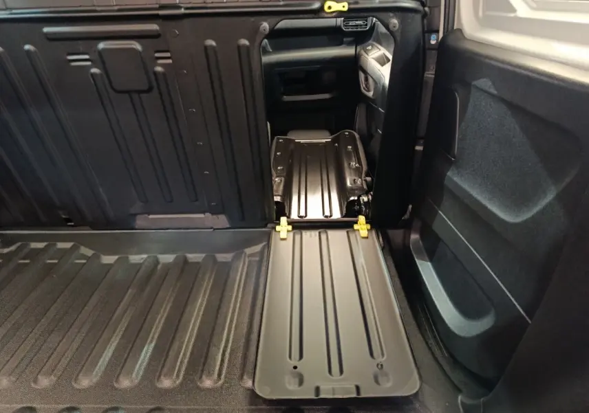Vue intérieure du coffre du Peugeot Partner blanc 2021, montrant la cloison pleine et le plancher de chargement noir.