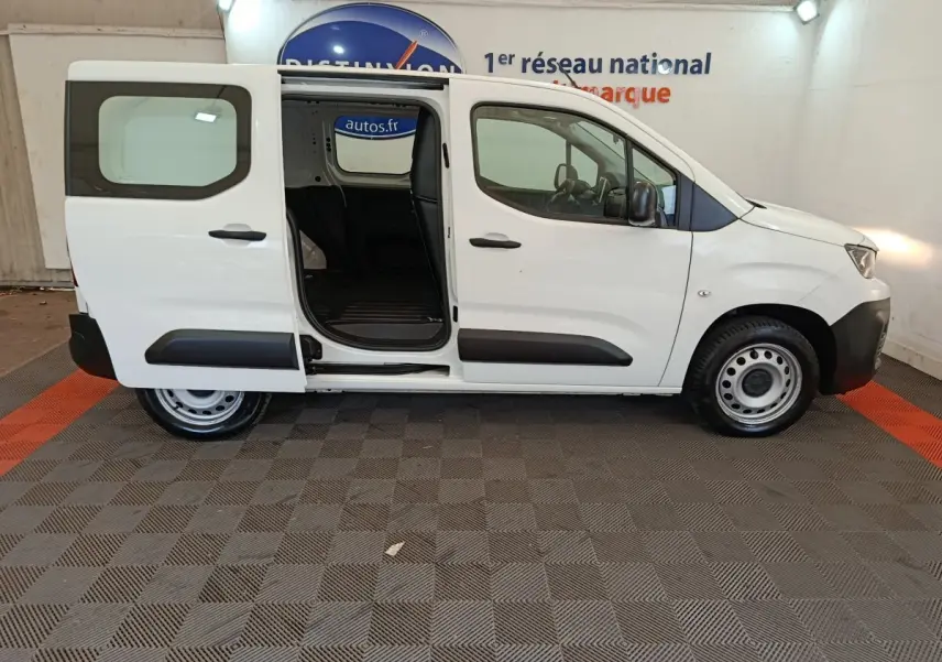 Vue latérale droite d’un Peugeot Partner blanc 2021 avec porte coulissante arrière ouverte, intérieur de chargement visible.