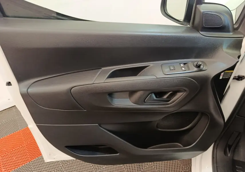 Intérieur côté conducteur du Peugeot Partner blanc 2021, porte avec commandes électriques et haut-parleur intégré.