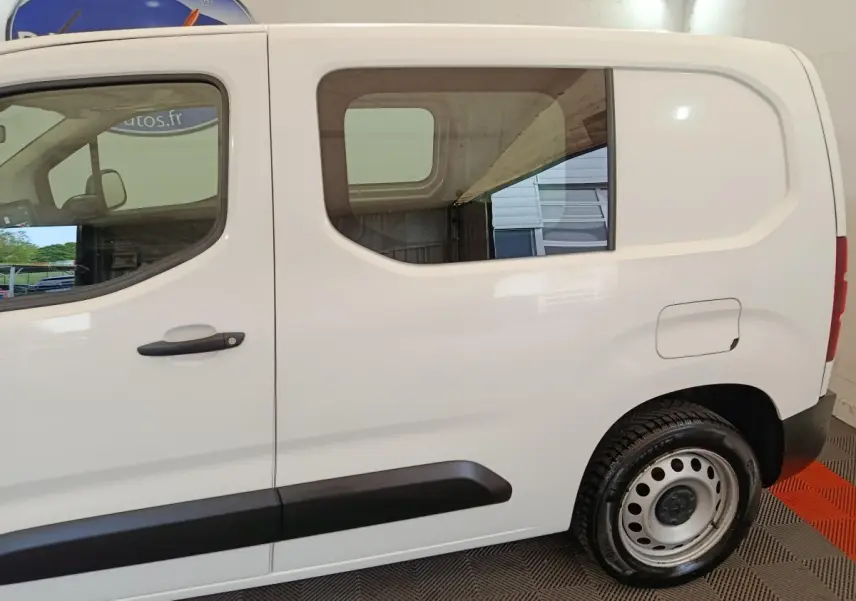 Vue latérale droite du Peugeot Partner blanc 2021 avec fenêtre arrière carrée et jante acier noire.